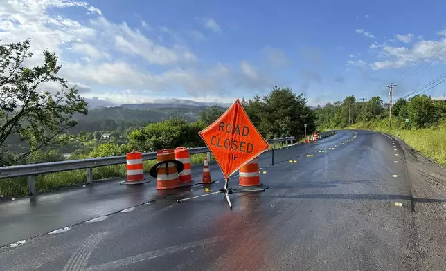 A sign warns of a road closed by flooding in Marshfield, Vt., Thursday, July 11, 2024. (AP Photo/Lisa Rathke)