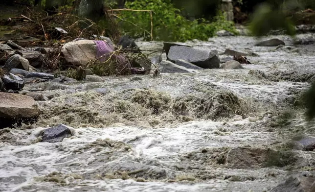 The Winooski River is seen flooded in Plainfield, Vermont. The village was badly hit by the flash flood last night, destroying two bridges and plenty of private houses, Thursday, July 11, 2024. (AP Photo/Dmitry Belyakov)