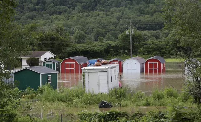 Water floods the lower level of homes, Thursday, July 11, 2024, in Bolton, Vt., near the Winooski River. (AP Photo/Hasan Jamali)