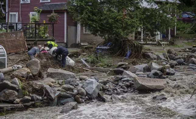 Residents collect debris following flooding caused by the remnants of Hurricane Beryl, Thursday, July 11, 2024, in Plainfield, Vt. (AP Photo/Dmitry Belyakov)