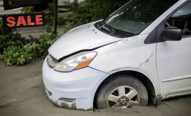 A vehicle is buried in silt following flooding caused by the remnants of Hurricane Beryl, Thursday, July 11, 2024, in Plainfield, Vt. (AP Photo/Dmitry Belyakov)