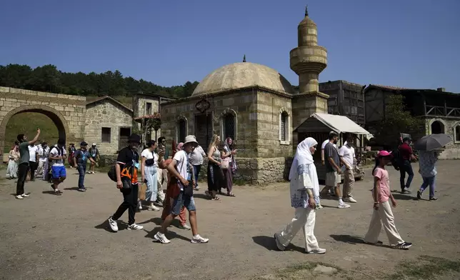 Tourists make a tour in Bozdag's outdoor film studio in Istanbul, Turkey, Wednesday, June 12, 2024. (AP Photo/Khalil Hamra)