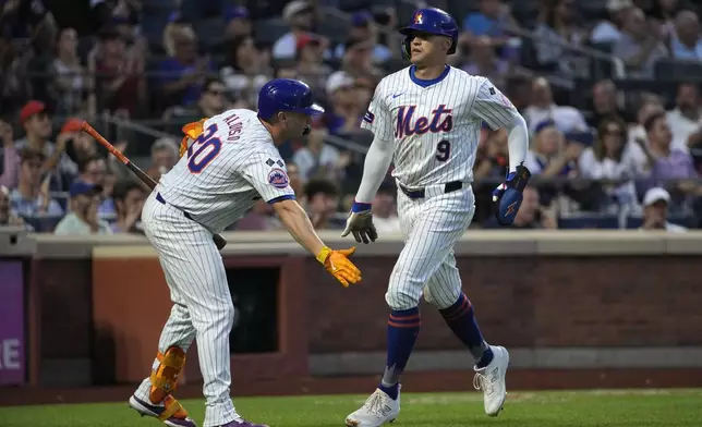 New York Mets' Pete Alonso, left, and Brandon Nimmo, right, celebrate as Nimmo scores on a single by J.D. Martinez during the fourth inning of a baseball game against the Minnesota Twins, Tuesday, July 30, 2024, in New York. (AP Photo/Pamela Smith)