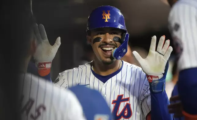 New York Mets' Mark Vientos celebrates hitting a home run in the dugout with teammates during the fifth inning of a baseball game against the Minnesota Twins, Tuesday, July 30, 2024, in New York. (AP Photo/Pamela Smith)