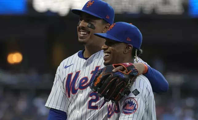 New York Mets' Mark Vientos, left, and Francisco Lindor, right, walk into the dugout together during the third inning of a baseball game against the Minnesota Twins, Tuesday, July 30, 2024, in New York. (AP Photo/Pamela Smith)