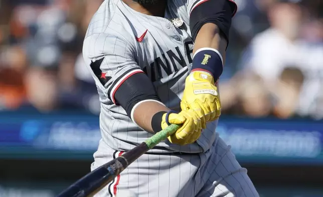 Minnesota Twins' Carlos Santana singles against the Detroit Tigers during the first inning of a baseball game, Saturday, July 27, 2024, in Detroit. (AP Photo/Duane Burleson)