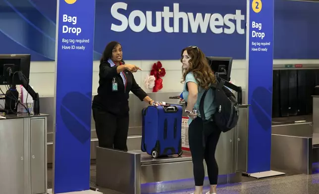 A passenger checks in for her Southwest Airlines flight at Midway International Airport in Chicago, Thursday, July 25, 2024. Southwest Airlines plans to drop the open-boarding system it has used for more than 50 years and will start assigning passengers to seats, just like all the other big airlines. (AP Photo/Teresa Crawford)