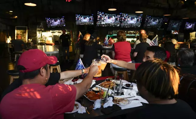 Supporters of former President Donald Trump drink beers as they watch him speak on television on Thursday, July 18, 2024, in Seal Beach, Calif. (AP Photo/Ashley Landis)