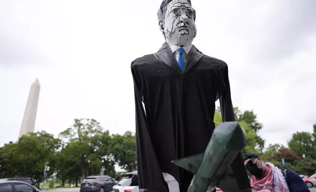 A large effigy of Israeli Prime Minister Benjamin Netanyahu is seen as protestors walk the streets, Wednesday, July 24, 2024, in Washington, ahead of a scheduled visit by Netanyahu at the U.S. Capitol. The Washington Monument is seen, left. (AP Photo/Mike Stewart)