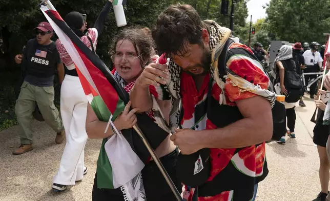 Demonstrators react after being exposed to a chemical irritant as they protest the visit of Israeli Prime Minister Benjamin Netanyahu on Capitol Hill, Wednesday, July 24, 2024, in Washington. (AP Photo/Jose Luis Magana)