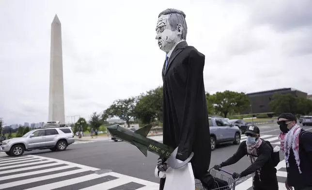 A large effigy of Israeli Prime Minister Benjamin Netanyahu is seen as protestors walk the streets, Wednesday, July 24, 2024, in Washington, ahead of a scheduled visit by Netanyahu at the U.S. Capitol. The Washington Monument is seen rear. (AP Photo/Mike Stewart)