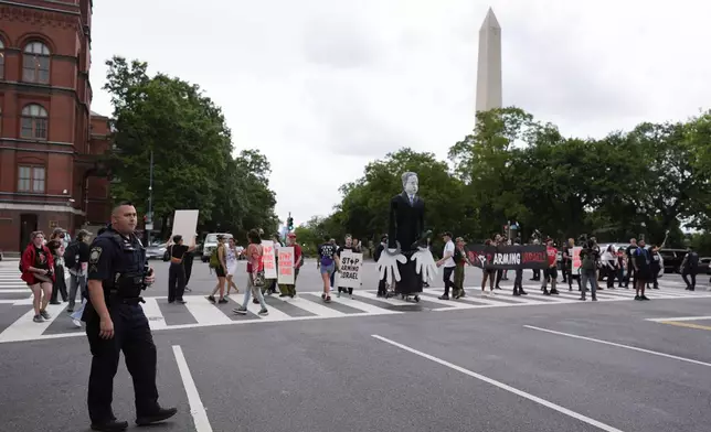 A large effigy of Israeli Prime Minister Benjamin Netanyahu, center, is seen as protestors attempt to block streets, Wednesday, July 24, 2024, in Washington, ahead of a scheduled visit by Netanyahu at the U.S. Capitol. The Washington Monument is seen, rear.(AP Photo/Mike Stewart)