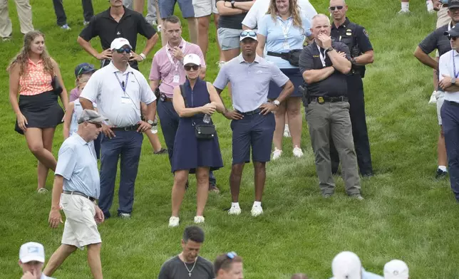 Tiger Woods, center, watches his son Charlie Woods play during the first round of stroke play of the U.S. Junior Amateur Golf Championship, Monday, July 22, 2024, in Bloomfield Township, Mich. (AP Photo/Carlos Osorio)