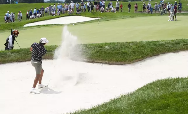 Charlie Woods hits onto the 17th green during the first round of stroke play of the U.S. Junior Amateur Golf Championship, Monday, July 22, 2024, in Bloomfield Township, Mich. (AP Photo/Carlos Osorio)