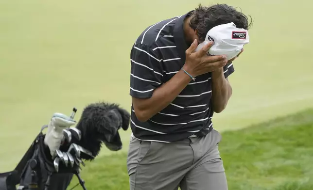 Charlie Woods walks off the 18th green during the first round of stroke play of the U.S. Junior Amateur Golf Championship, Monday, July 22, 2024, in Bloomfield Township, Mich. (AP Photo/Carlos Osorio)