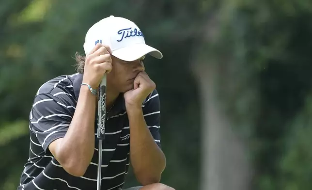 Charlie Woods pauses on the 14th green during the first round of stroke play of the U.S. Junior Amateur Golf Championship, Monday, July 22, 2024, in Bloomfield Township, Mich. (AP Photo/Carlos Osorio)