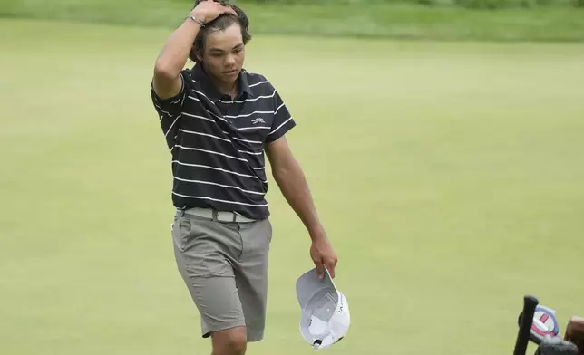 Charlie Woods walks off the 18th green during the first round of stroke play of the U.S. Junior Amateur Golf Championship, Monday, July 22, 2024, in Bloomfield Township, Mich. (AP Photo/Carlos Osorio)