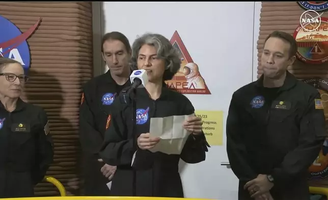 In this image made from video provided by NASA, Anca Selariu, the crew members of the first CHAPEA mission, speaks in front of other members, from left to right, Kelly Haston, Ross Brockwell, and Nathan Jones, Saturday, July 6, 2024, at Johnson Space Center in Houston, Texas. The crew of a NASA mission to Mars emerged from their craft after a yearlong voyage that never left Earth. The four volunteers crew members spent more than 12 months inside NASA's first simulated Mars environment at Johnson Space Center in Houston, coming out of the artificial alien environment Saturday. (NASA via AP)