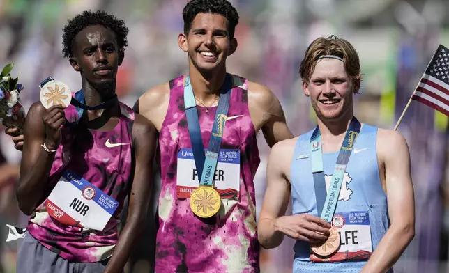 First place winner Grant Fisher, center, and second place winner Abdihamid Nur, left, and third place finisher Parker Wolfe pose for a photo after the wins the men's 5000-meter final run during the U.S. Track and Field Olympic Team Trials, Sunday, June 30, 2024, in Eugene, Ore. (AP Photo/George Walker IV)