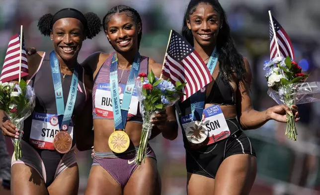 First place winner Masai Russell, center, Alaysha Johnson, at second place, right stand with third place winner Grace Stark after the win the women's 100-meter hurdles final during the U.S. Track and Field Olympic Team Trials, Sunday, June 30, 2024, in Eugene, Ore. (AP Photo/George Walker IV)