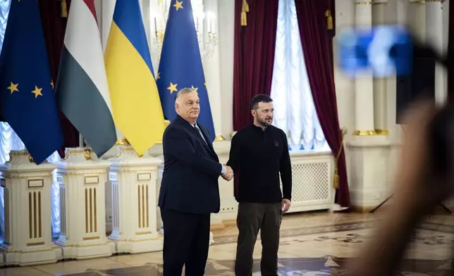 In this picture issued by the Hungarian PM's Press Office Ukrainian President Volodymyr Zelenskyy, right, welcomes Hungarian Prime Minister Viktor Orban in Kyiv, Ukraine, Tuesday, July 2, 2024. (Zoltan Fischer/Hungarian PM's Press Office/MTI via AP)