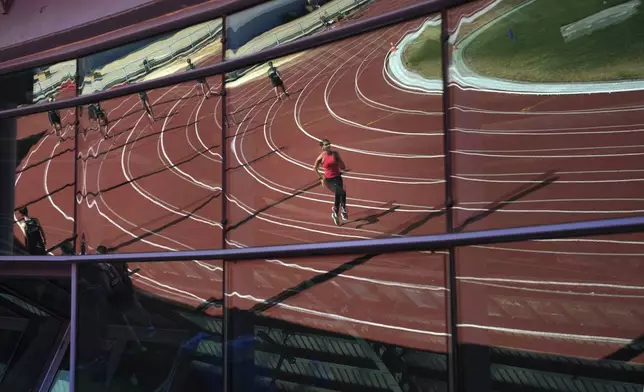 Ukrainian high jumper Kateryna Tabashnyk runs at the stadium that she shares with other Ukrainians training to qualify for the Paris Olympics in Monte Gordo, Portugal, Tuesday, May 7, 2024. She and the other Ukrainian athletes training in Monte Gordo have formed something of a support group. They talk about parents, homes, and Russian attacks. (AP Photo/Emilio Morenatti)