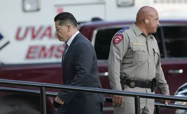 Former Uvalde Consolidated Independent School District police officer Adrian Gonzales, left, arrives at the Uvalde County Courthouse, Thursday, July 25, 2024, in Uvalde, Texas. Gonzales made his first court appearance on charges of abandoning and failing to protect children. (AP Photo/Eric Gay)