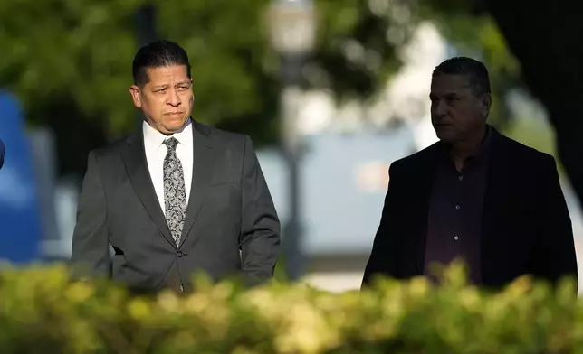 Former Uvalde Consolidated Independent School District police officer Adrian Gonzales, left, arrives at the Uvalde County Courthouse, Thursday, July 25, 2024, in Uvalde, Texas. Gonzales made his first court appearance on charges of abandoning and failing to protect children. (AP Photo/Eric Gay)