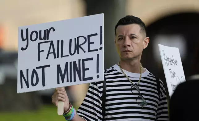 James Alvarado holds signs outside of the Uvalde County Courthouse as he shows his support for the families and victims of the shootings at Robbs Elementary School, Thursday, July 25, 2024, in Uvalde, Texas. Former Uvalde Consolidated Independent School District police officer Adrian Gonzales made his first court appearance on charges of abandoning and failing to protect children. (AP Photo/Eric Gay)