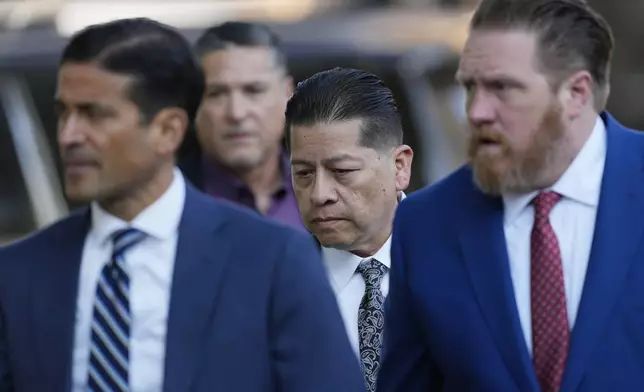 Former Uvalde Consolidated Independent School District police officer Adrian Gonzales, center, arrives with his attorneys at the Uvalde County Courthouse for a court appearance, Thursday, July 25, 2024, in Uvalde, Texas. (AP Photo/Eric Gay)