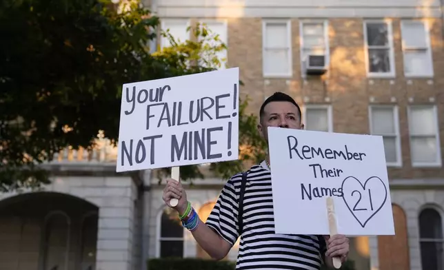 James Alvarado holds signs outside of the Uvalde County Courthouse as he shows his support for the families and victims of the shootings at Robbs Elementary School, Thursday, July 25, 2024, in Uvalde, Texas. Former Uvalde Consolidated Independent School District police officer Adrian Gonzales made his first court appearance on charges of abandoning and failing to protect children. (AP Photo/Eric Gay)