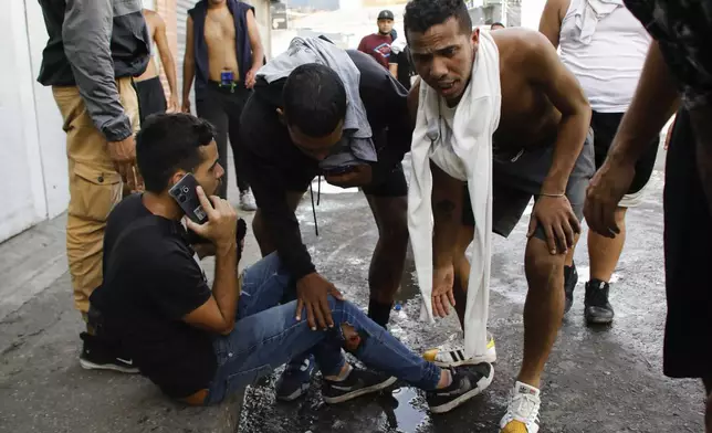 Protesters look after Shuamy Gomez, who was wounded during clashes with police, in demonstrations against the official election results declaring President Nicolas Maduro's reelection, the day after the vote in Caracas Venezuela, Monday, July 29, 2024. (AP Photo/Cristian Hernandez)