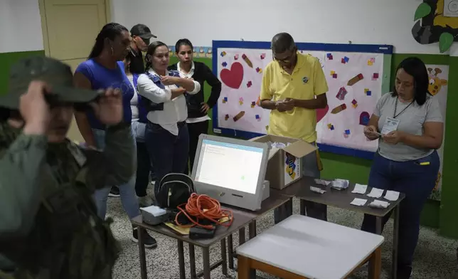 Electoral officials tally votes after polls closed for presidential elections in Caracas, Venezuela, Sunday, July 28, 2024. (AP Photo/Matias Delacroix)