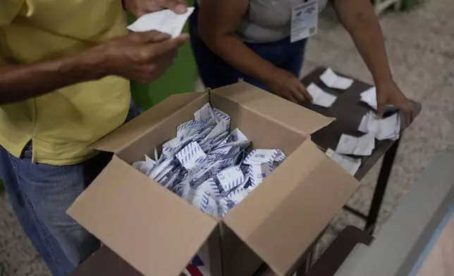 Electoral officials tally votes after polls closed for presidential elections in Caracas, Venezuela, Sunday, July 28, 2024. (AP Photo/Matias Delacroix)