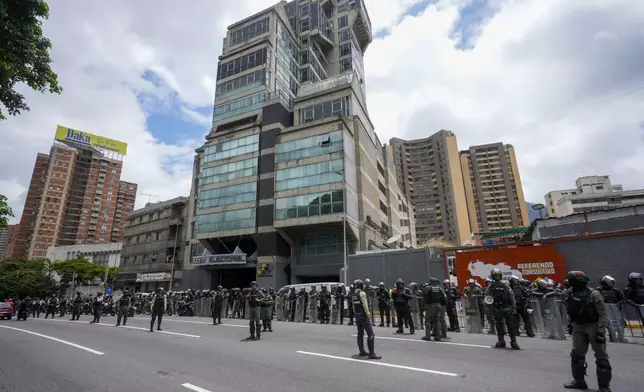 Police and National Guards stand outside the National Election Council (CNE) the day after the presidential election in Caracas, Venezuela, Monday, July 29, 2024. (AP Photo/Fernando Vergara)