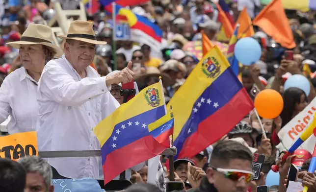 Venezuelan opposition presidential candidate Edmundo Gonzalez, accompanied by wife Mercedes, flashes a thumbs up at supporters as he arrives to his campaign rally in Barinas, Venezuela, Saturday, July 6, 2024. (AP Photo/Ariana Cubillos)