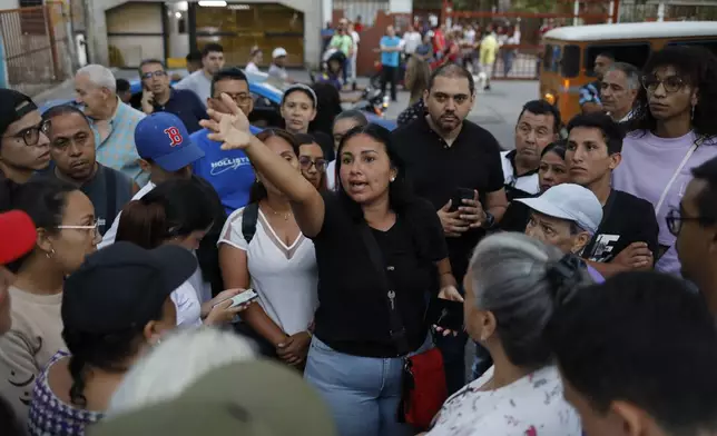 Opposition supporters listen to organizer Deillily Rodriguez as they gather to witness election officials tally the votes after polls closed for the presidential election in Caracas, Venezuela, Sunday, July 28, 2024. (AP Photo/Cristian Hernandez)