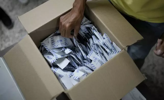 Electoral officials tally votes after polls closed for presidential elections in Caracas, Venezuela, Sunday, July 28, 2024. (AP Photo/Matias Delacroix)