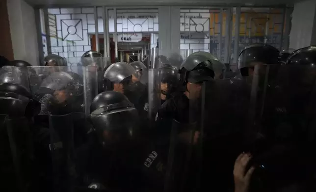 Police guard a voting center during the presidential election in Caracas, Venezuela, Sunday, July 28, 2024. (AP Photo/Matias Delacroix)