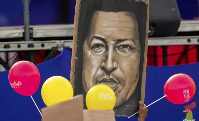 Supporters of President Nicolas Maduro hold a poster of late former Venezuelan Presiden Hugo Chavez during an election campaign rally in Caracas, Venezuela, Thursday, July 25, 2024. Maduro is seeking re-election for a third term in the July 28 vote. (AP Photo/Fernando Vergara)