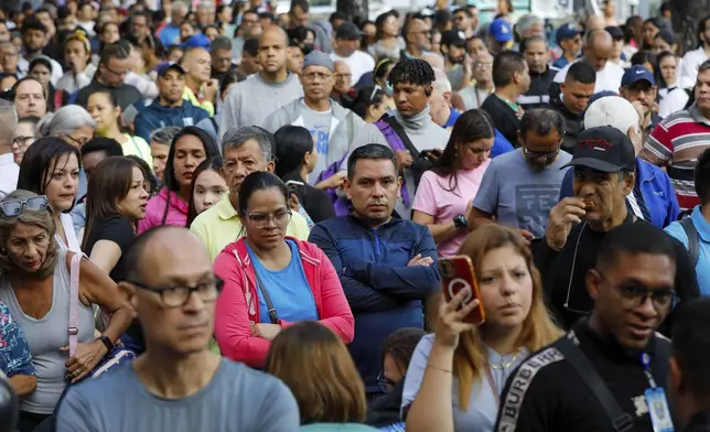 Voters line up to vote outside the Andres Bello School voting center during the presidential election in Caracas, Venezuela, Sunday, July 28, 2024. (AP Photo/Cristian Hernandez)