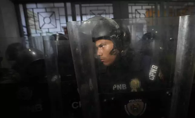 Police guard a voting center during the presidential election in Caracas, Venezuela, Sunday, July 28, 2024. (AP Photo/Matias Delacroix)