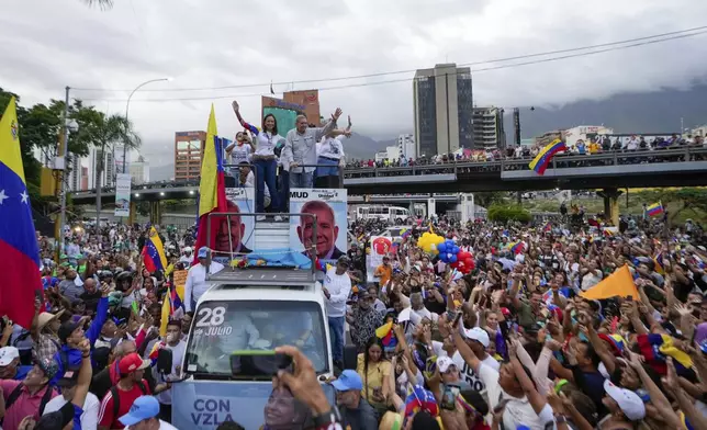 Opposition leader Maria Corina Machado, left, and the opposition's presidential candidate Edmundo Gonzalez wave during a closing election campaign rally in Caracas, Venezuela, Thursday, July 25, 2024. The presidential election is set for July 28. (AP Photo/Matias Delacroix)