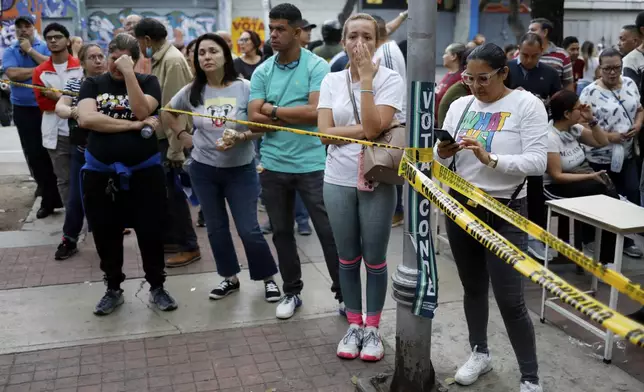 Voters wait to access the Andres Bello School, the main polling center in Caracas, Venezuela, during presidential election on Sunday, July 28, 2024. (AP Photo/Cristian Hernandez)