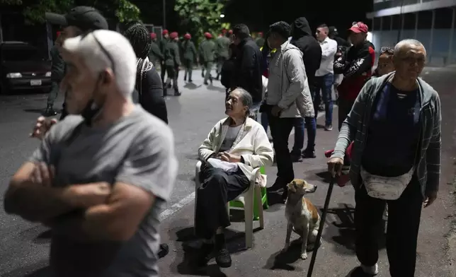 Voters line up at a polling station before the polls open for the presidential elections in Caracas, Venezuela, Sunday, July 28, 2024. (AP Photo/Matias Delacroix)