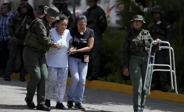 Military personnel help assist an elderly voter during the presidential election in Caracas, Venezuela, Sunday, July 28, 2024. (AP Photo/Fernando Vergara)