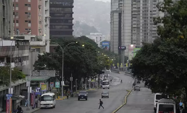 A man crosses an avenue in Caracas, Venezuela, Monday, July 29, 2024, the day after the presidential election. (AP Photo/Matias Delacroix)