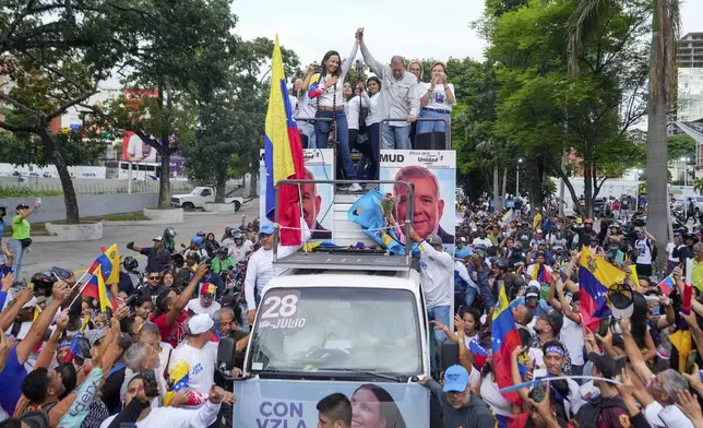 Opposition leader Maria Corina Machado, right, and opposition's presidential candidate Edmundo Gonzalez wave during a closing election campaign rally in Caracas, Venezuela, Thursday, July 25, 2024. The presidential election is set for July 28. (AP Photo/Matias Delacroix)