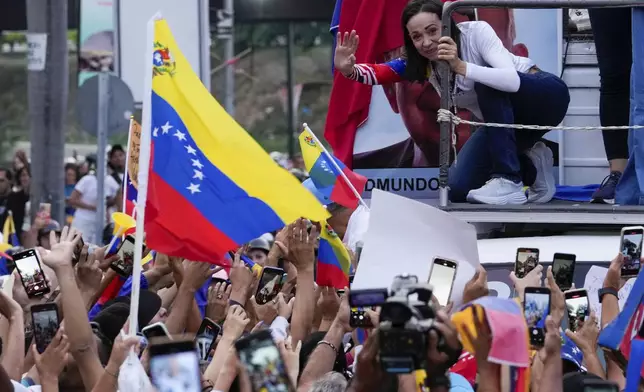 Opposition leader Maria Corina Machado waves during a closing election campaign rally of presidential candidate Edmundo Gonzalez in Caracas, Venezuela, Thursday, July 25, 2024. The presidential election is set for July 28. (AP Photo/Matias Delacroix)