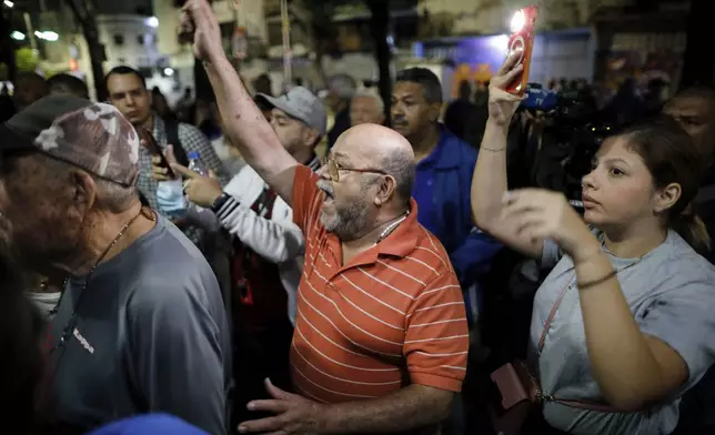 A voter waiting in line shouts as access for opposition poll watchers is delayed at the Andres Bello School, prior to the opening of the polls for the presidential elections in Caracas, Venezuela, Sunday, July 28, 2024. (AP Photo/Cristian Hernandez)